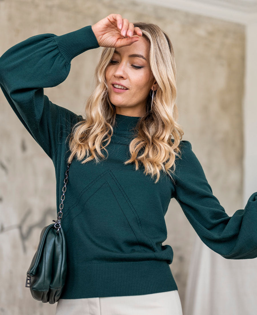 Dark green PLEIN PUBLIQUE turtleneck sweater shown indoors.