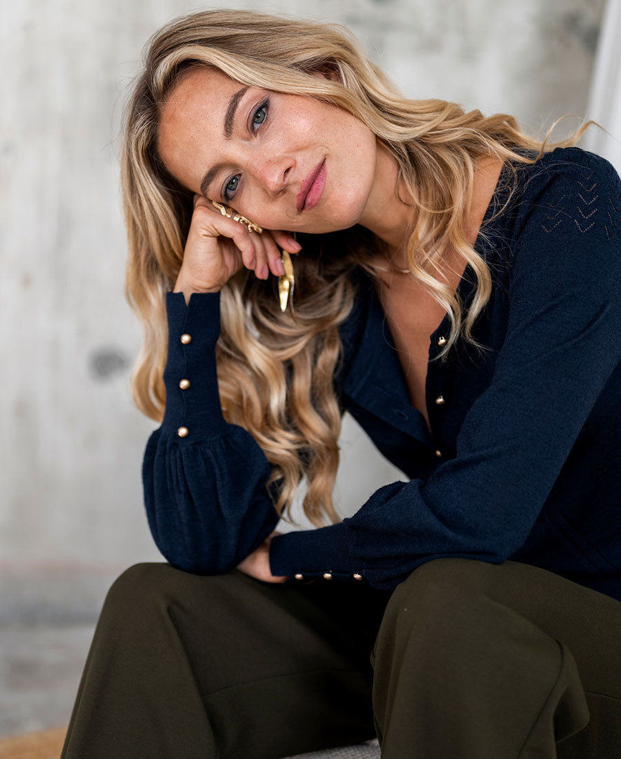 Navy blue and gold cardigan from Plein Publique, shown on model.
