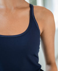 Close-up of a person wearing the Luxe Navy Camisole by PLEIN PUBLIQUE, highlighting the shoulder and collarbone.