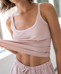 Dusty pink luxe cami top in a soft material, shown indoors.