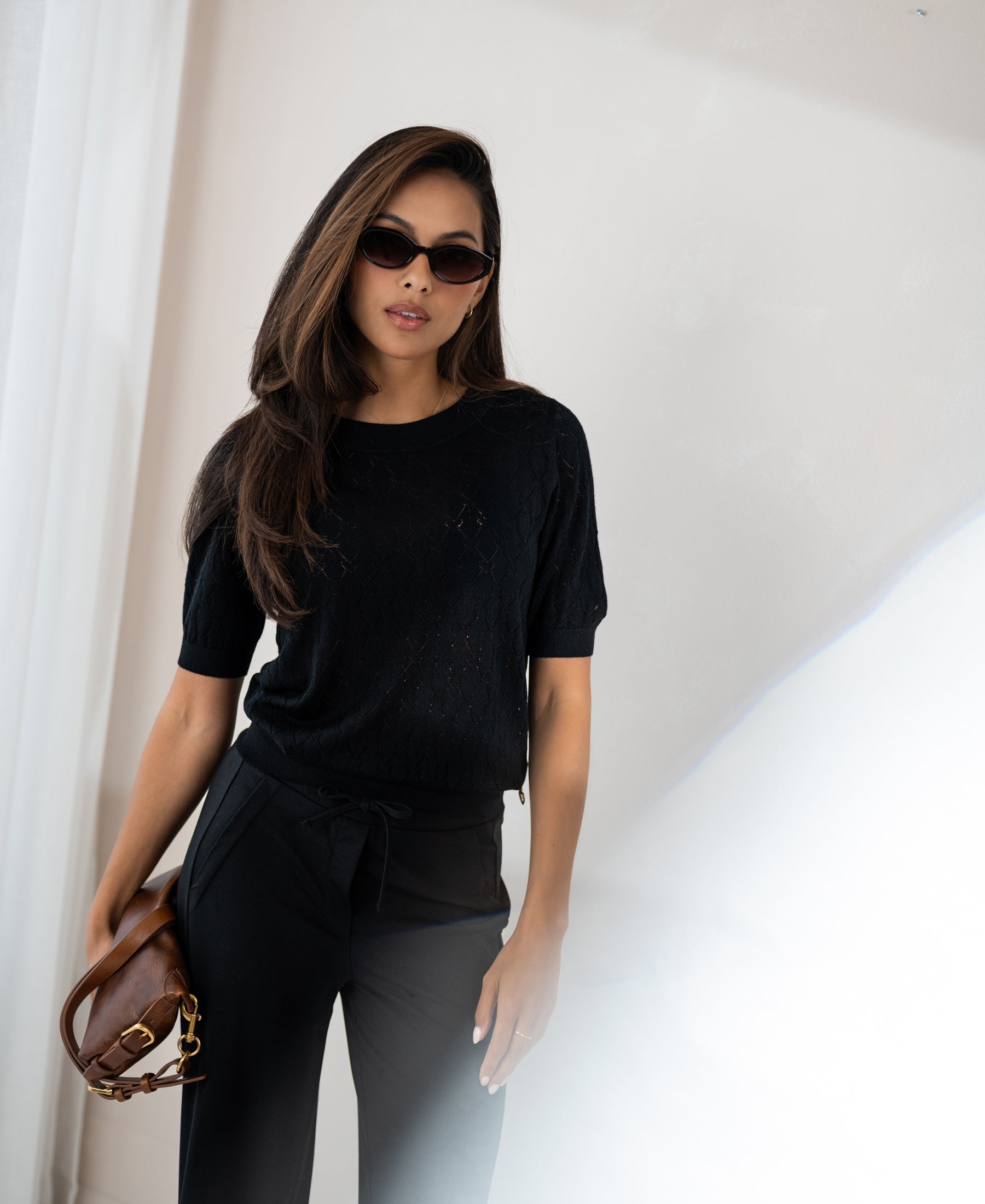 Black sweater with heart pattern from LE BATTANT by PLEIN PUBLIQUE shown indoors.
