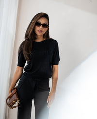 Black sweater with heart pattern from LE BATTANT by PLEIN PUBLIQUE shown indoors.