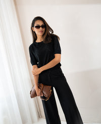 Black PLEIN PUBLIQUE sweater with heart pattern LE BATTANT worn by a woman indoors.