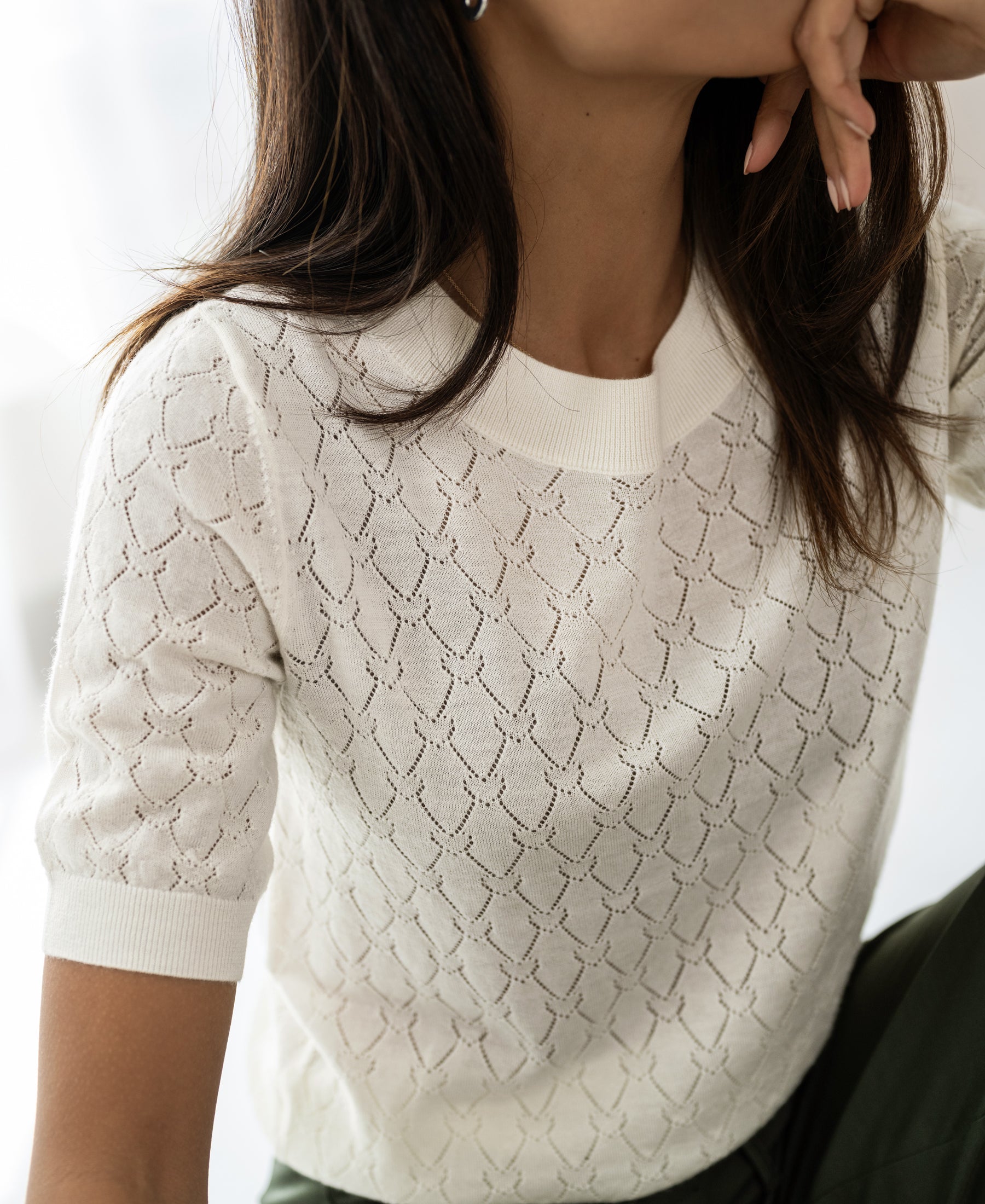 Ivory sweater with heart pattern by PLEIN PUBLIQUE, shown on a woman.