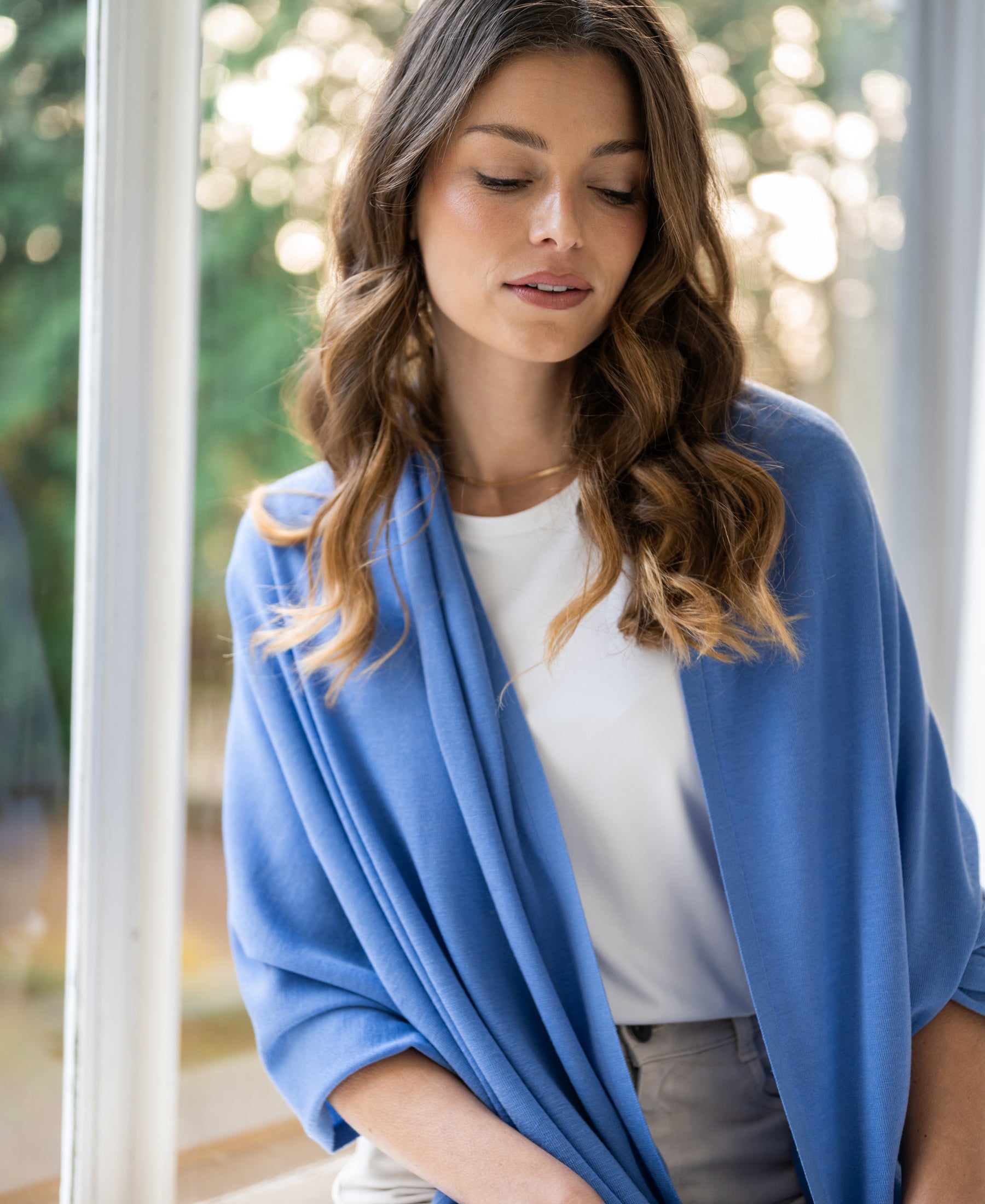 Merino wool wrap scarf in Monaco blue, shown draped over the shoulders.