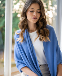 Merino wool wrap scarf in Monaco blue, shown draped over the shoulders.