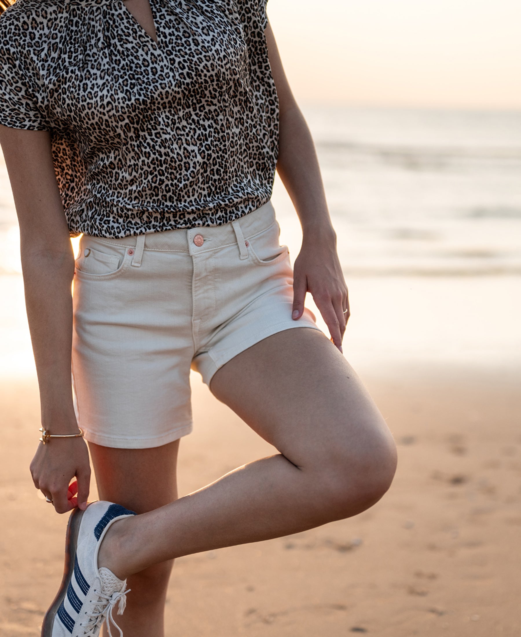 Cream short LA BILLY by PLEIN PUBLIQUE shown worn on a person standing on a sandy beach at sunset.