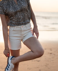 Cream short LA BILLY by PLEIN PUBLIQUE shown worn on a person standing on a sandy beach at sunset.