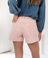 Blush-colored LA BILLY short skirt by PLEIN PUBLIQUE, shown from the back indoors.