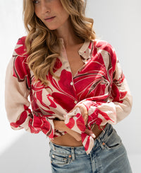 Red print LA BINOCLE blouse by PLEIN PUBLIQUE shown on a woman against a plain light background.