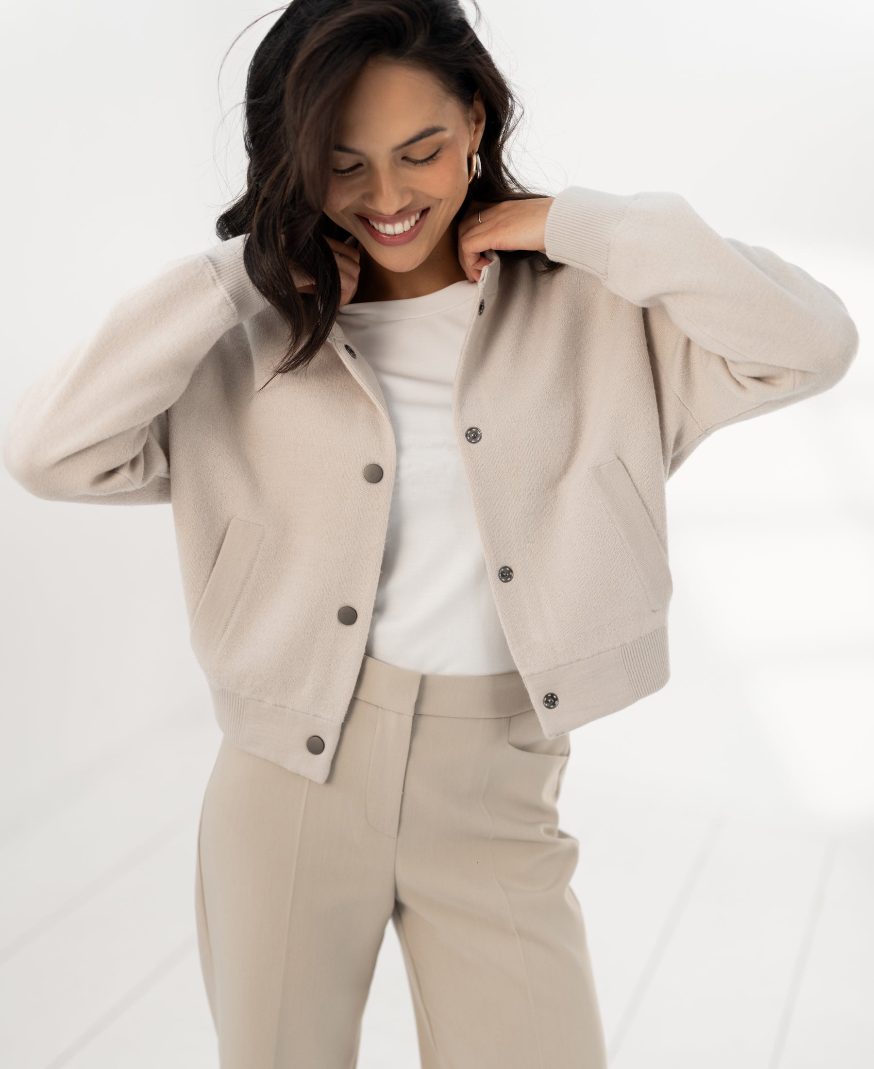 Beige bomber jacket, called LA BOMBA by Plein Publique, shown in a bright space.
