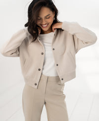 Beige bomber jacket, called LA BOMBA by Plein Publique, shown in a bright space.