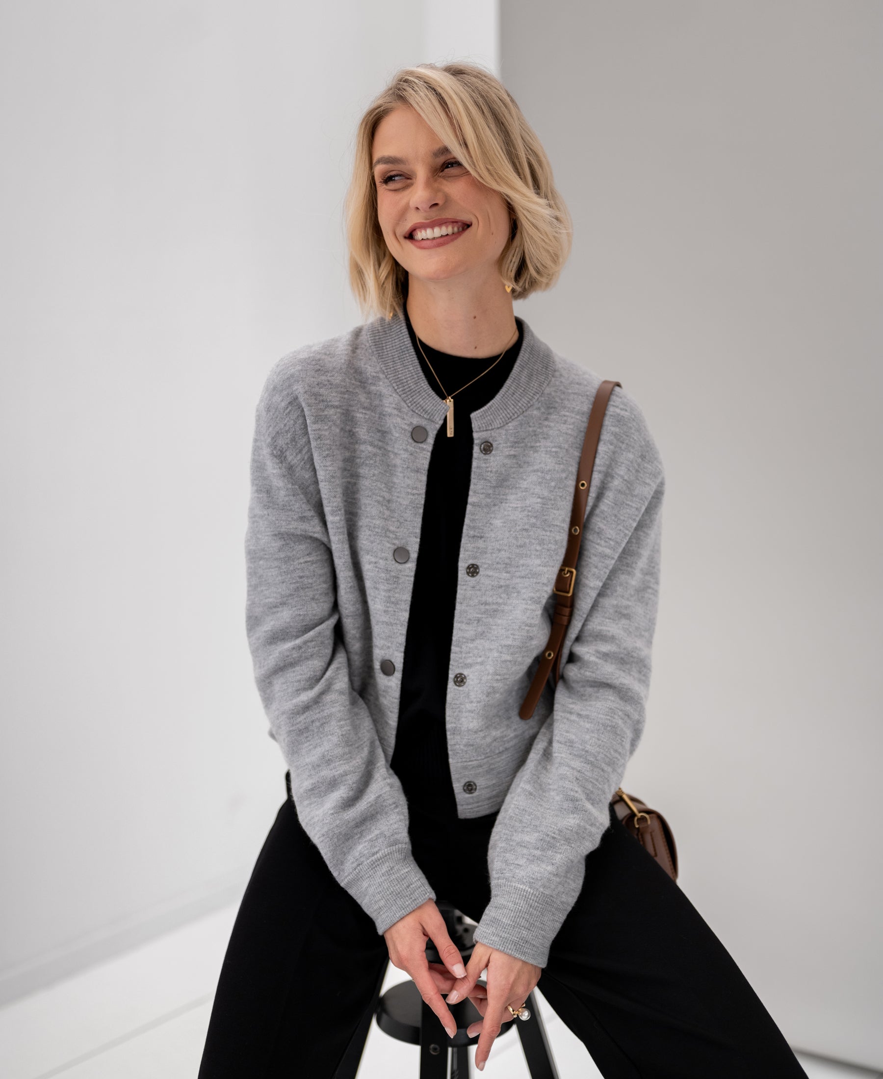 Light grey melange bomber jacket, shown front view on a seated model.