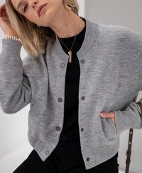 Woman poses in gray melange bomber jacket, hand in pocket.
