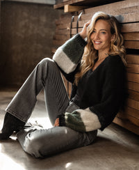Black striped fluffy vest by PLEIN PUBLIQUE shown in front of stacked wooden planks.
