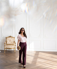 Woman wears a ribbed blush pink T-shirt as she walks across a bright room.