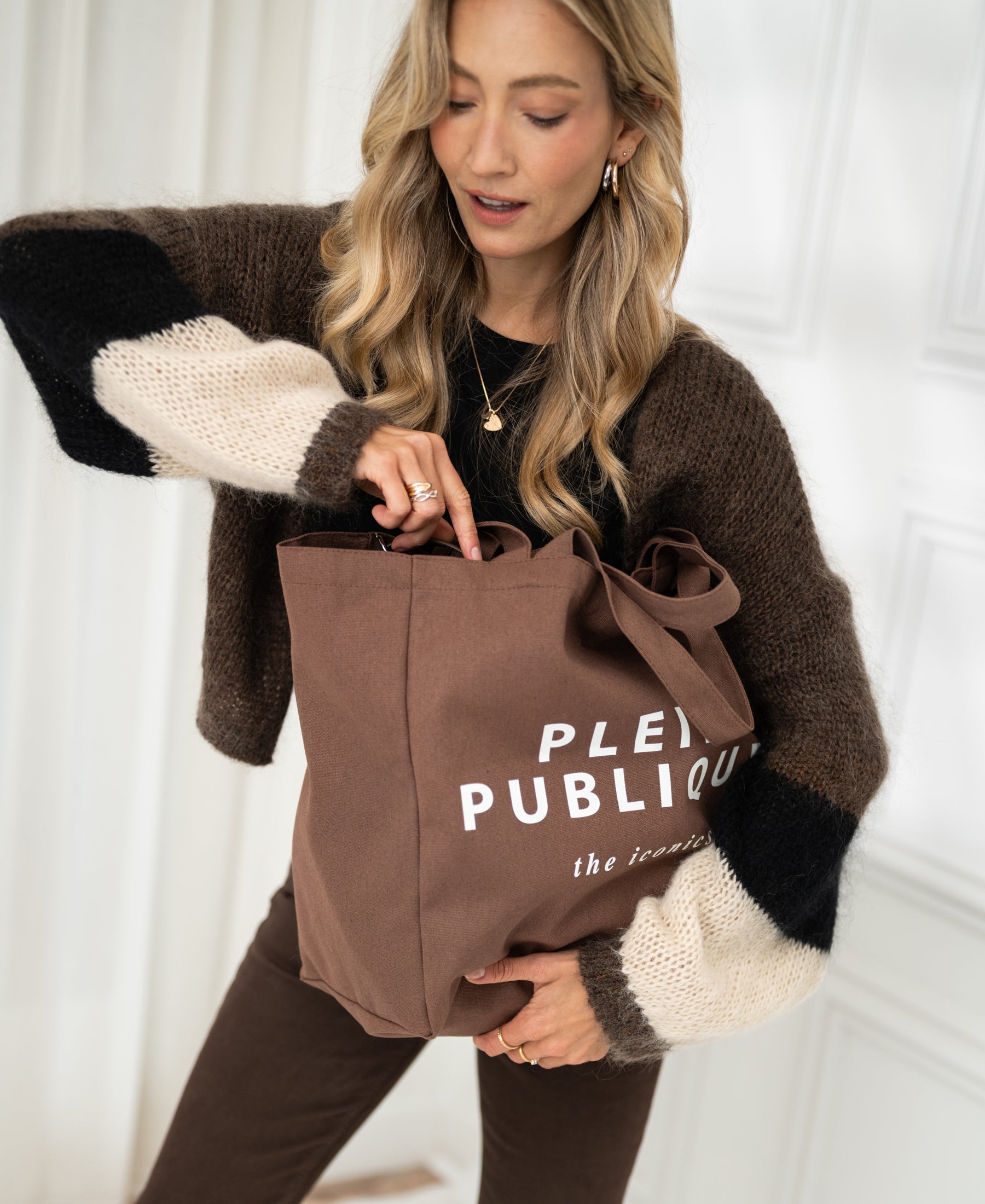 Brown canvas tote bag with text on the front, by PLEIN PUBLIQUE, shown from above.