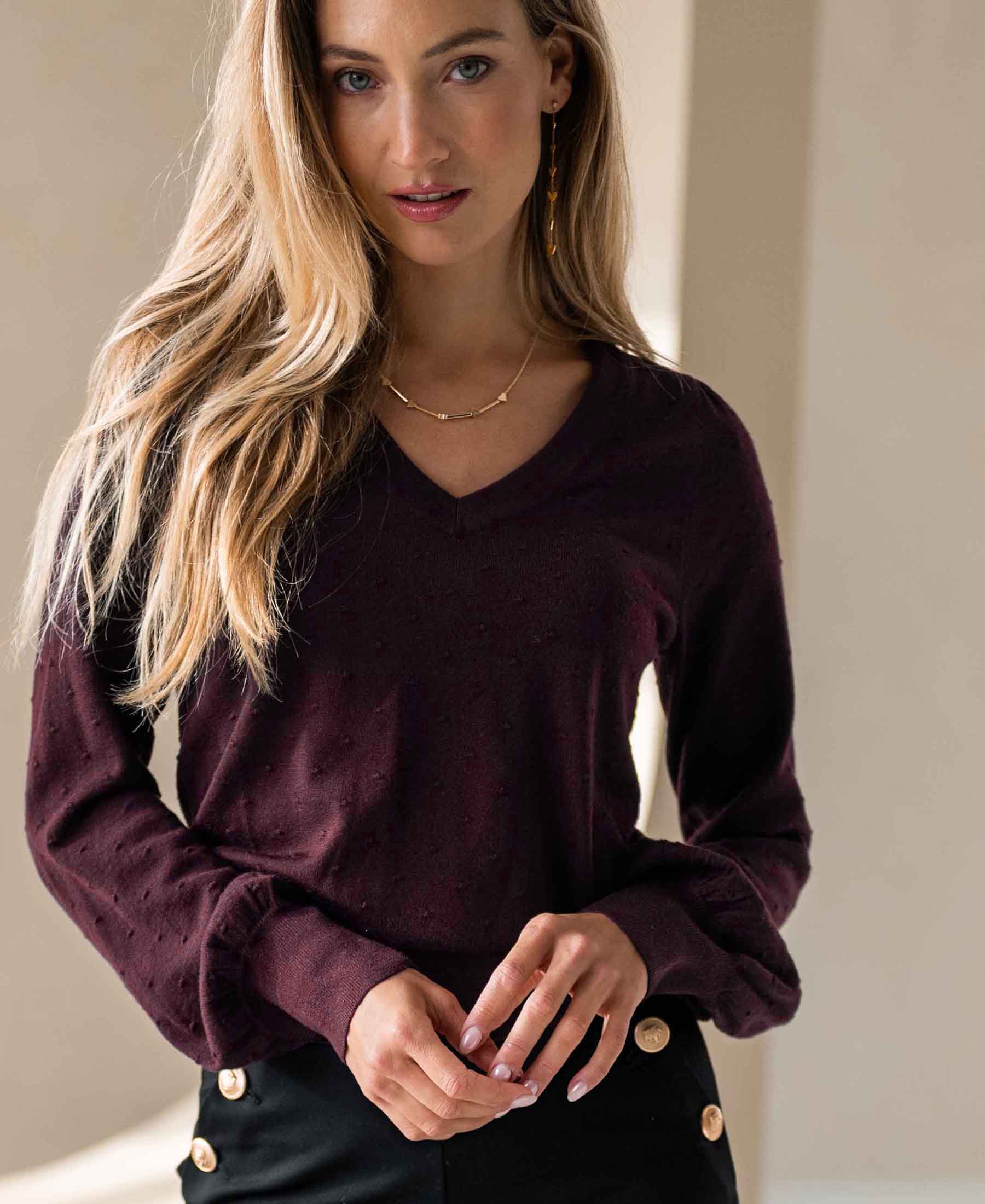 Merino wool V-neck sweater LA VICTORIA in Bordeaux by PLEIN PUBLIQUE worn indoors.