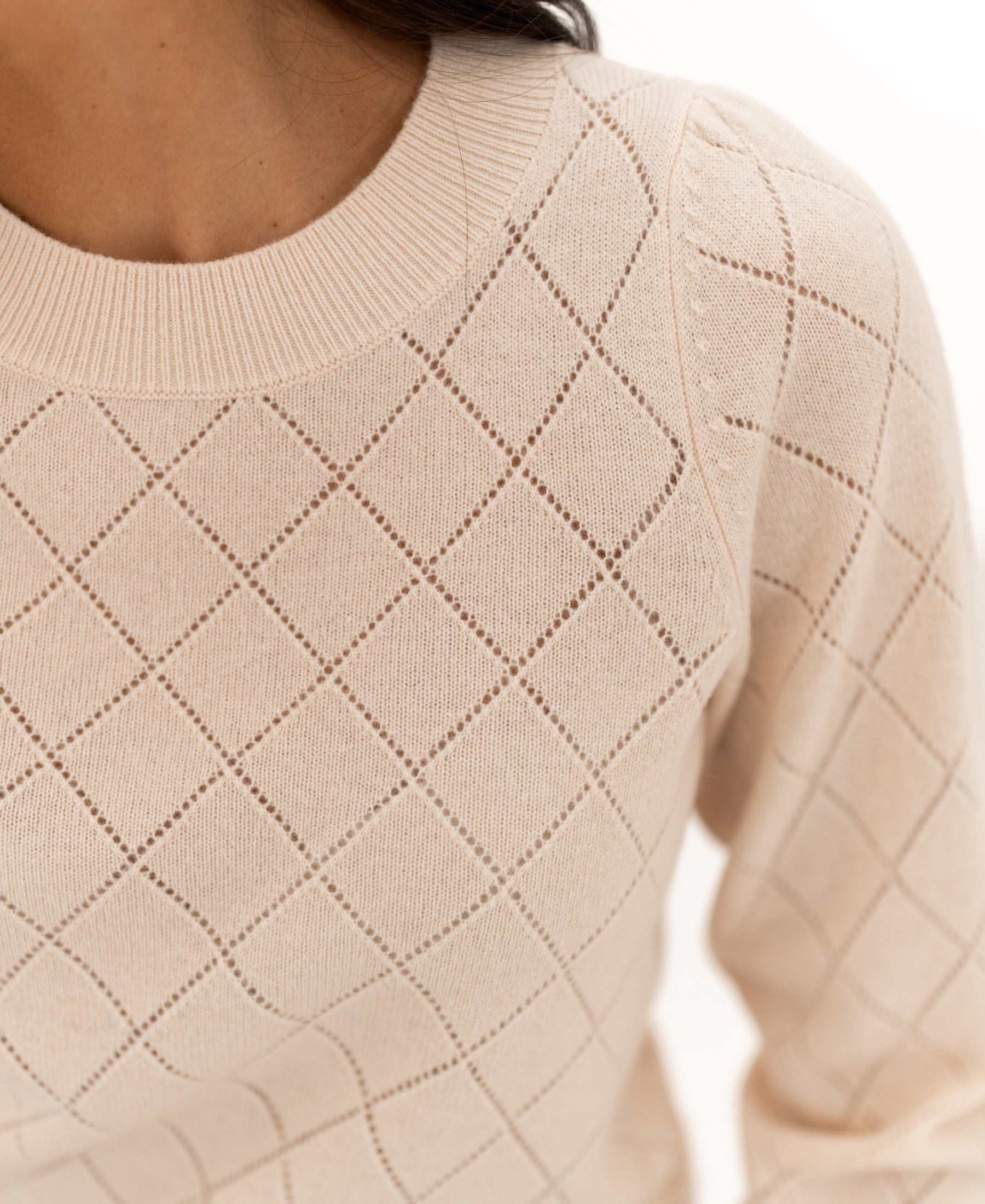 Close-up of the PLEIN PUBLIQUE argyle-patterned merino sweater in butter yellow.