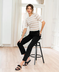 Black slim straight leg cropped jeans with a 7/8 length, shown on a seated model.