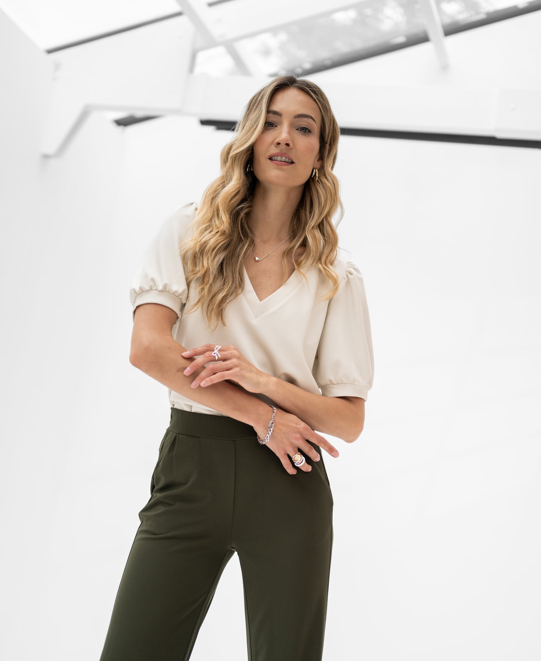 Beige LA CELINE Stone travel top by OVERIG shown on a woman in a modern space.