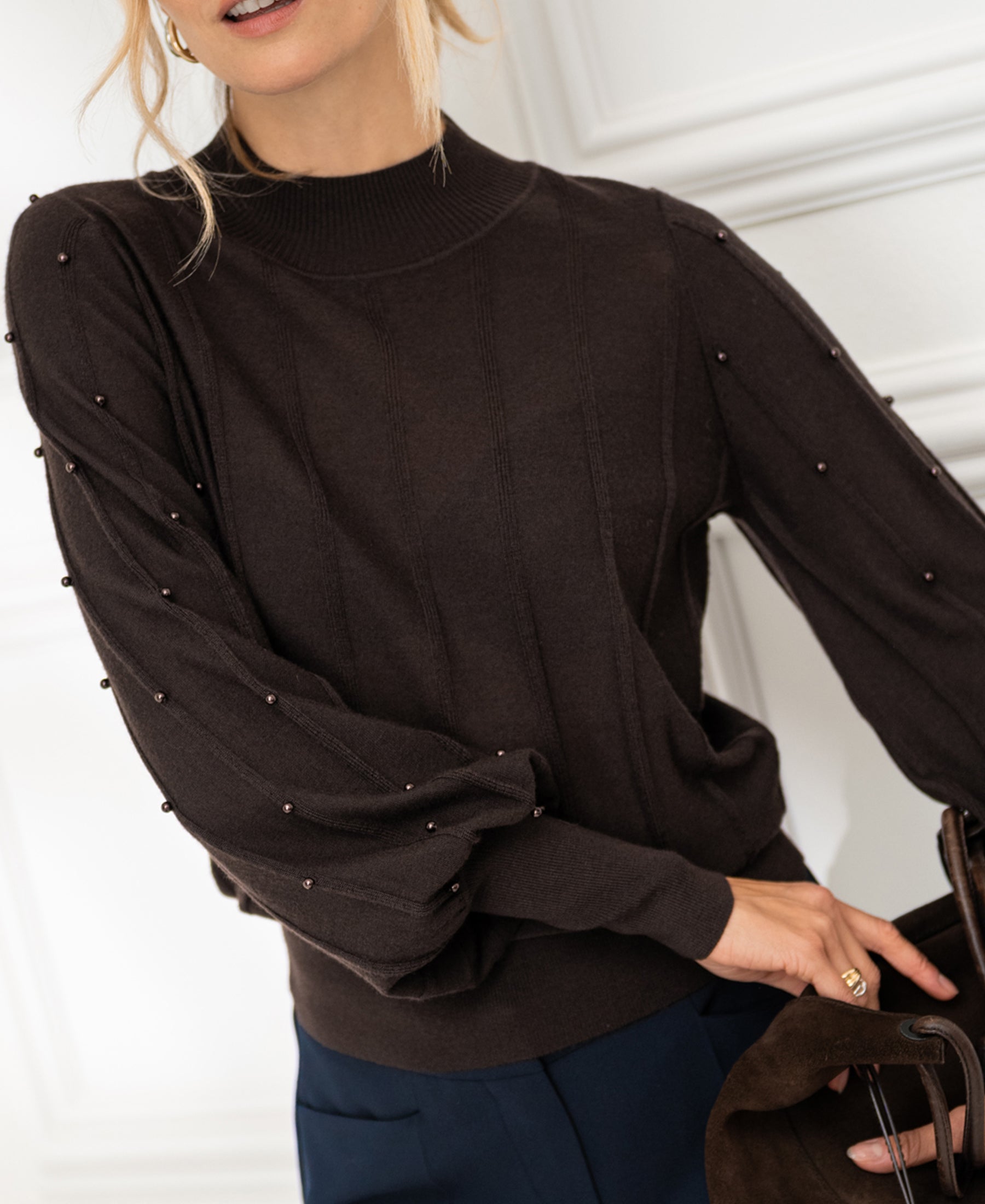 Brown beaded turtleneck sweater by PLEIN PUBLIQUE shown indoors.