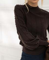 PLEIN PUBLIQUE turtleneck sweater with beaded details in pure chocolate brown, shown indoors.