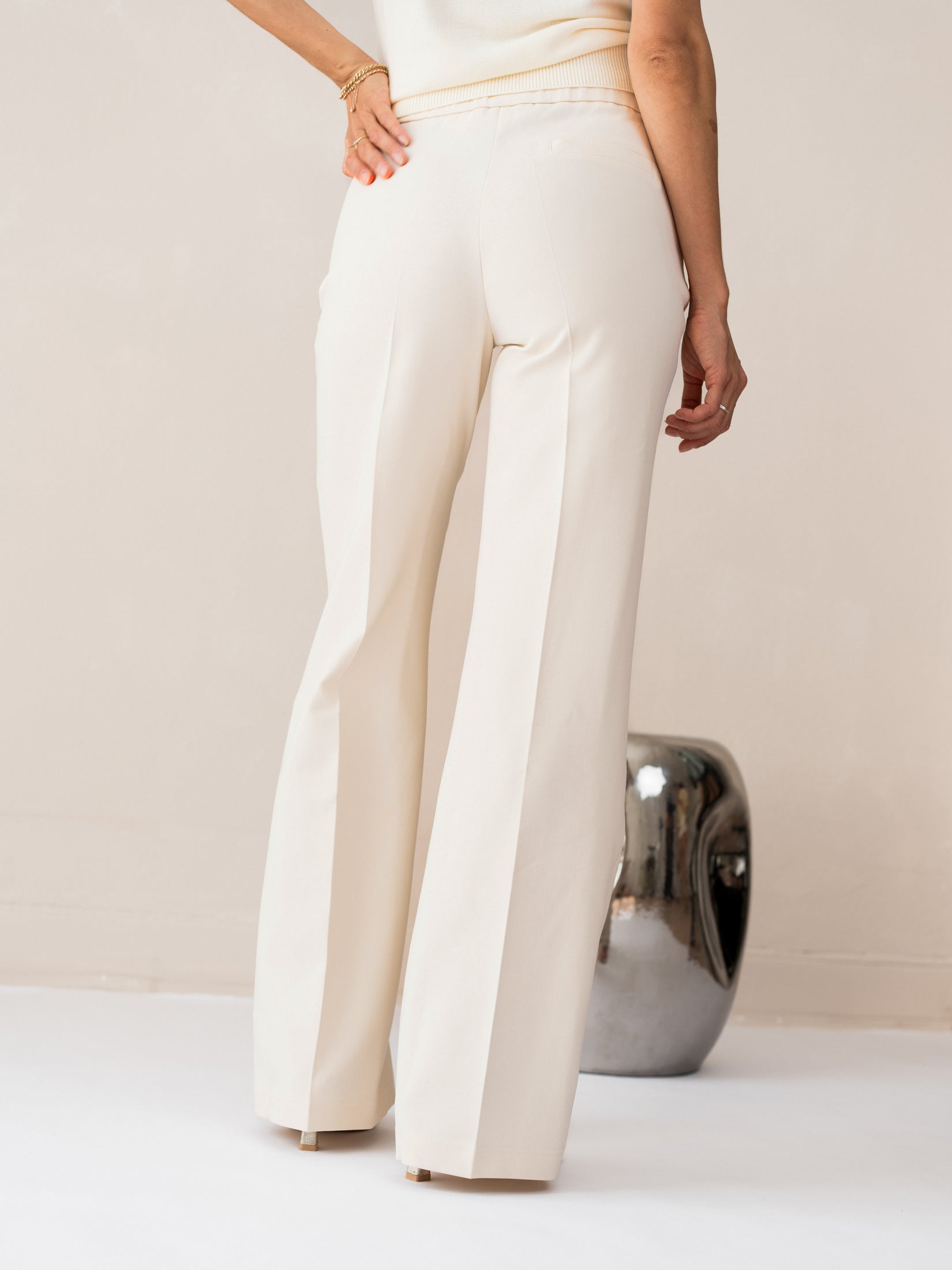 Back view of cream wide-leg pants in LE CENTRE style; model stands with back to camera.