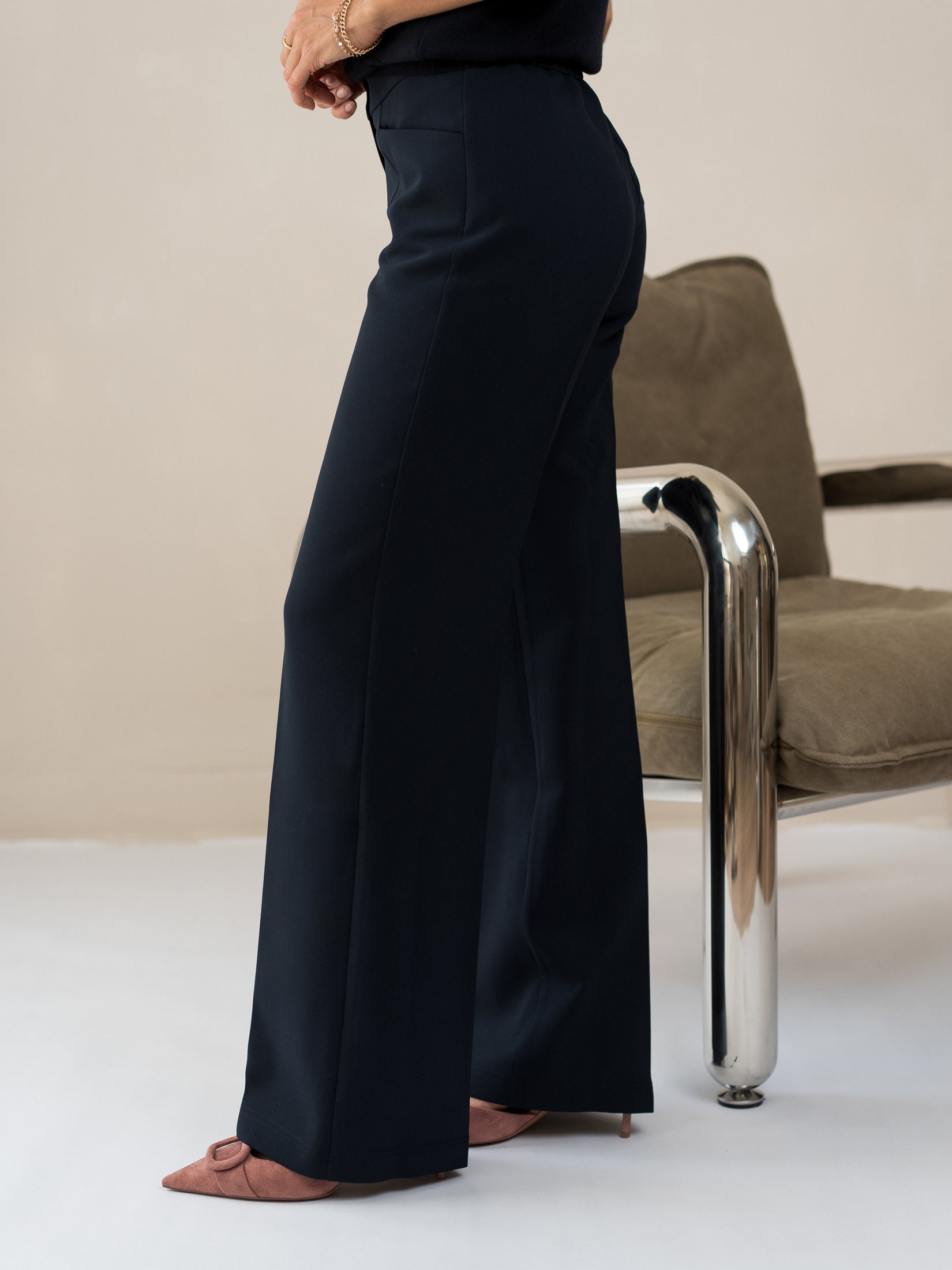 Side view of a person wearing dark blue LE CENTRE trousers by PLEIN PUBLIQUE.