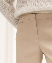 Wide-leg light sand trousers, waist to mid-thigh view.