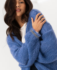 Woman wearing the PLEIN PUBLIQUE Fluffy Vest LA CHERIE Blue with arms crossed.