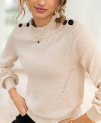 Woman wearing the LA CLIQUE Light Sand Merino Sweater from PLEIN PUBLIQUE, indoors.