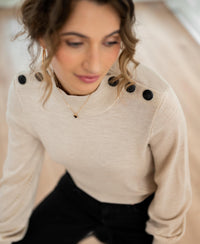 Merino wool sweater in sand with black shoulder buttons.