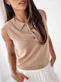 Sleeveless soft camel polo top by Plein Publique, shown on a woman with one hand in her pocket.