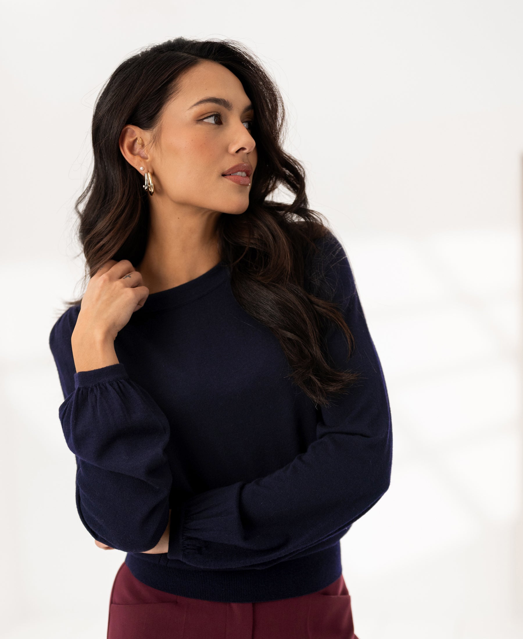 Dark blue Merino wool sweater LA COEUR by PLEIN PUBLIQUE, shown from the left in a bright room.