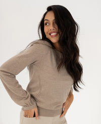 Woman wears a sand-colored PLEIN PUBLIQUE LA COEUR merino wool sweater.