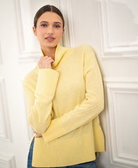 Woman wearing a LA COZY light yellow turtleneck sweater by PLEIN PUBLIQUE, seen from the front.