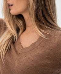 Merino wool V-neck sweater in Chai Tea color from PLEIN PUBLIQUE, shown on a woman with long blonde hair.