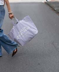 Large canvas tote bag in lilac, shown held by model.