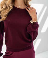 Woman wearing a Bordeaux red LA COEUR sweater by PLEIN PUBLIQUE.