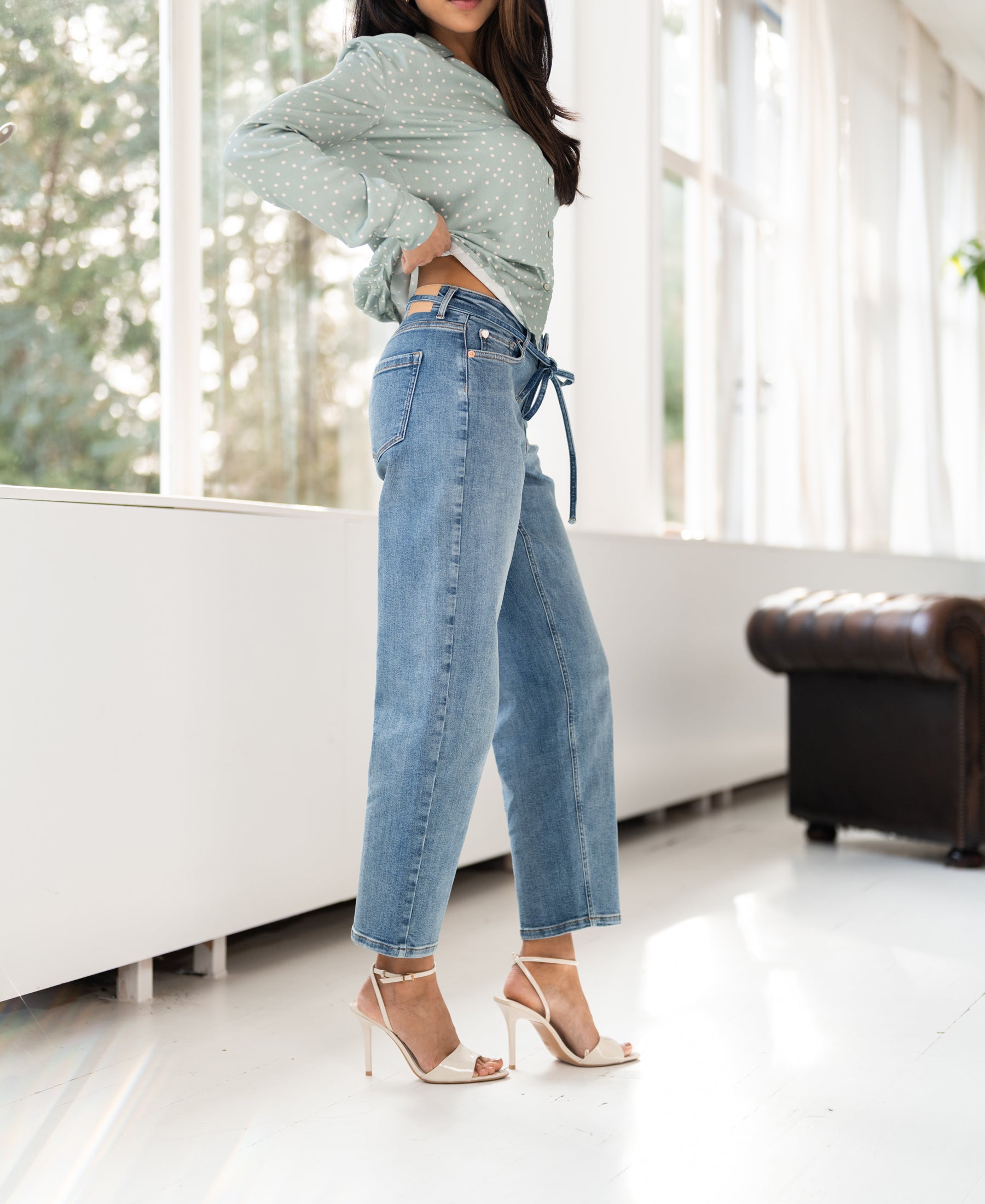 Light stone cropped jeans in a bright room.