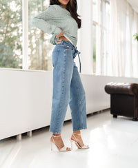 Light stone cropped jeans in a bright room.