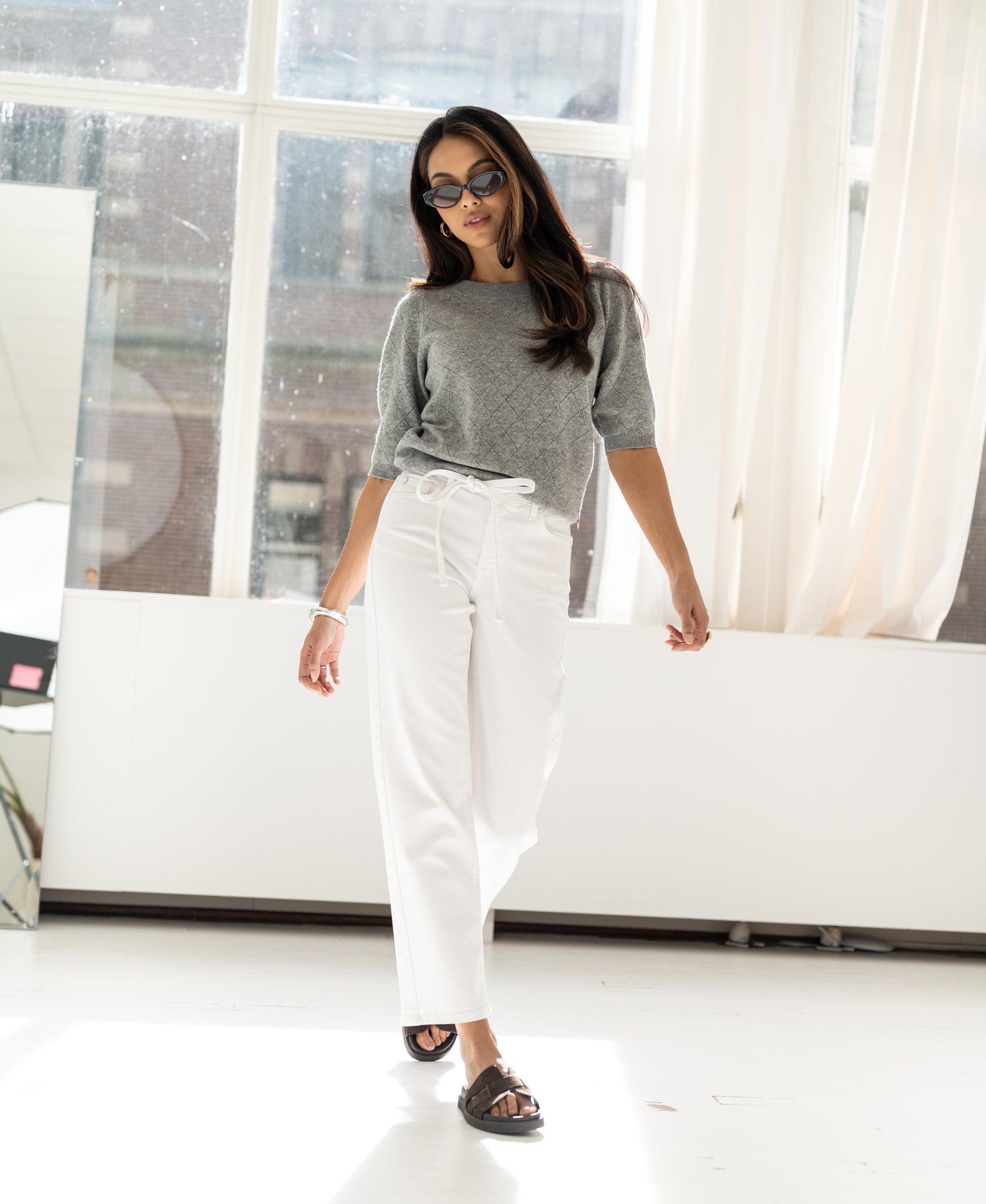 Cropped white jeans by Plein Publique, style Le Dean, shown worn indoors.