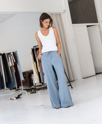 Woman wears light blue Tencel denim jeans called LE DEGAS by PLEIN PUBLIQUE; product shown from the front.