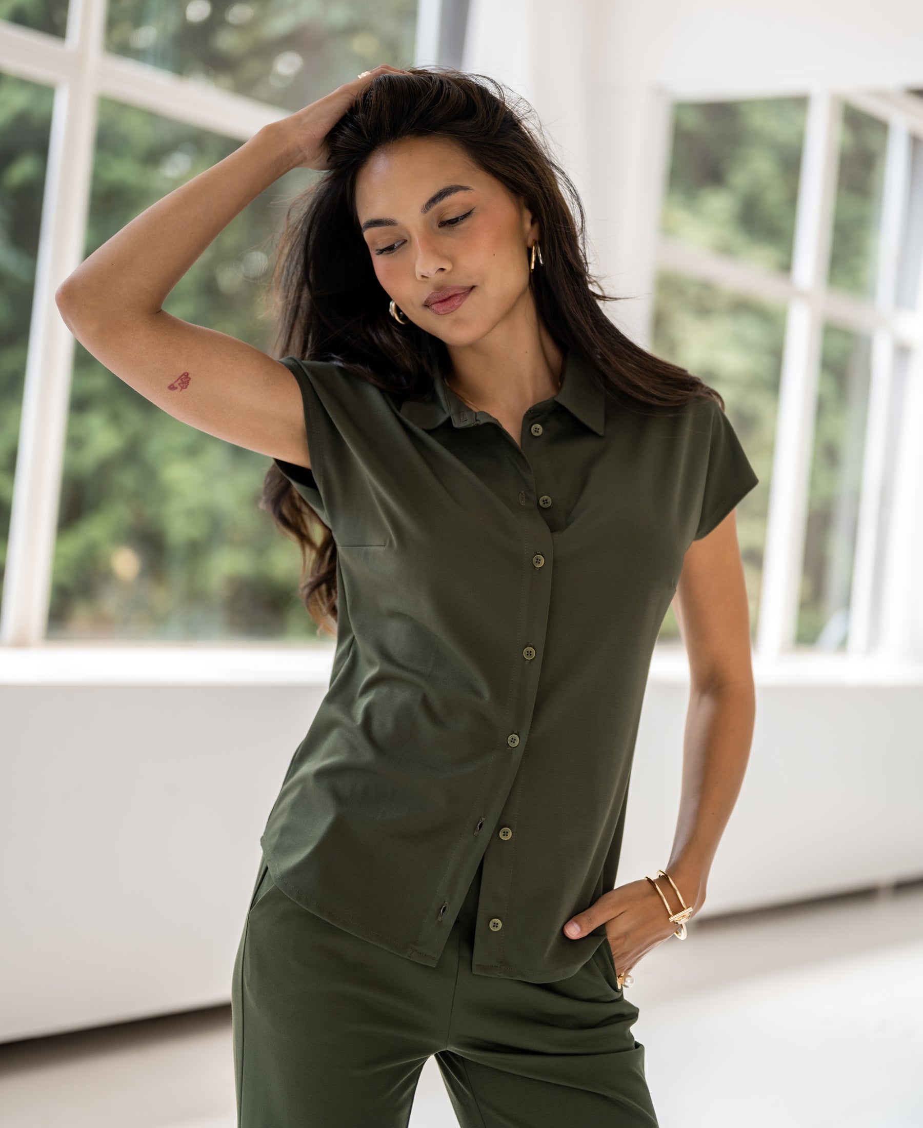 Army green travel blouse in a relaxed fit, shown indoors.