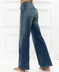 Wide leg blue vintage jeans in cotton denim, shown from mid-back down against a white floor.