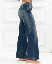 Wide leg blue vintage jeans by Plein Publique, side view, shown against a white paneled background.