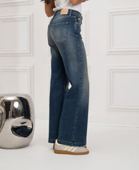 Wide leg blue vintage jeans by PLEIN PUBLIQUE shown in a white room.