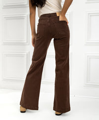 Woman facing away wearing PLEIN PUBLIQUE dark brown jeans with hand in back pocket.