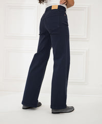 Dark blue PLEIN PUBLIQUE LES DEUX jeans displayed in a white room.
